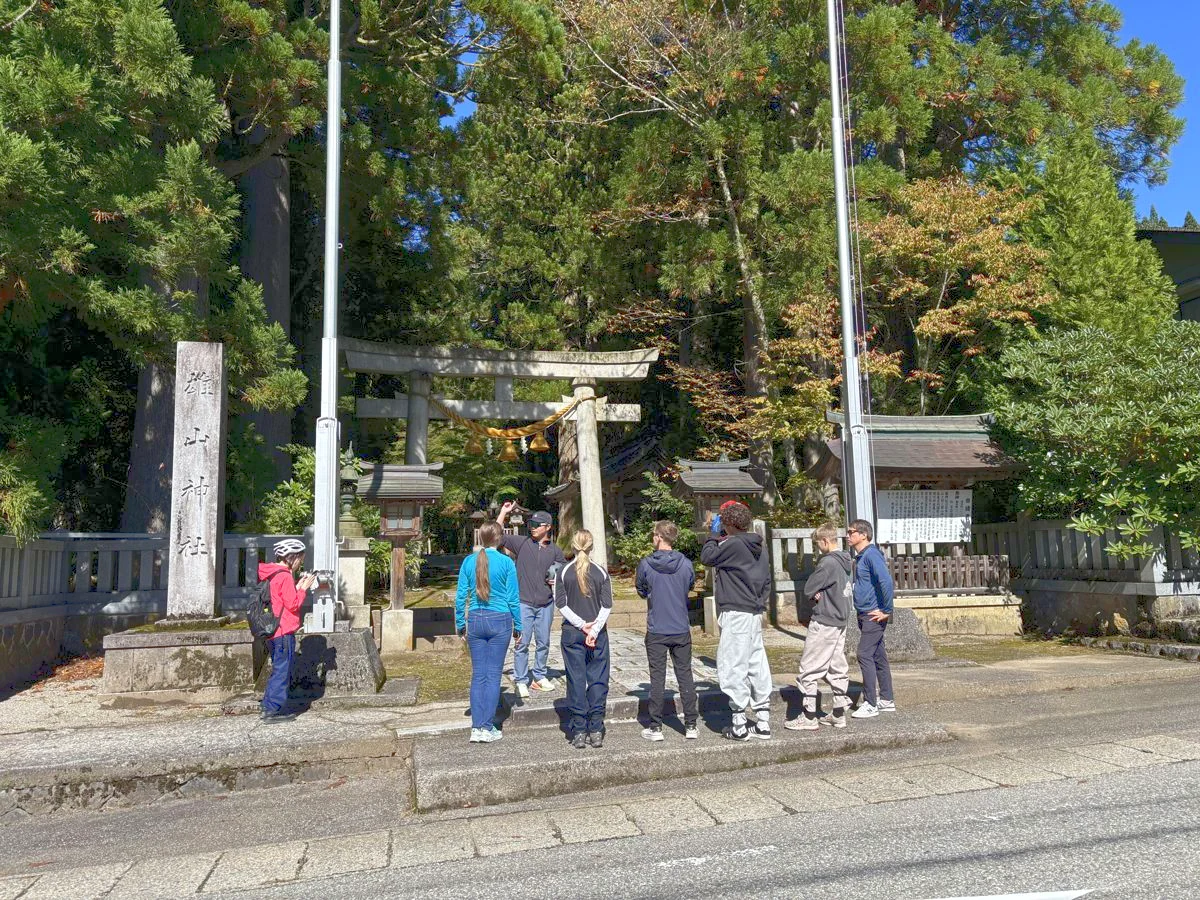芦峅寺の雄山神社の鳥居の前で、ガイドの説明を聞く参加者