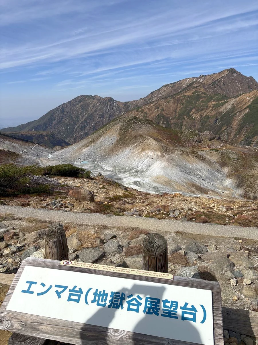 エンマ台(地獄谷展望台)の看板と、その先に見える地獄谷