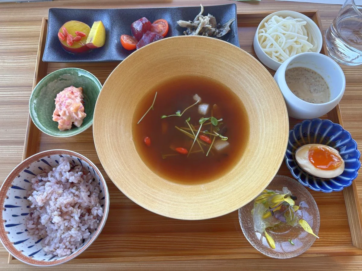 スープを中心に、雑穀ご飯、煮卵、小鉢が並んだランチのお膳