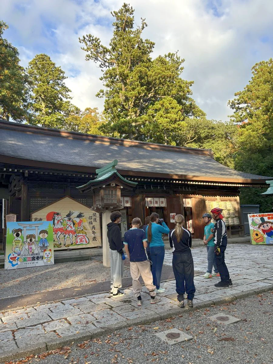 夕方の雄山神社前立社壇の前で、ガイドの説明を聞く参加者
