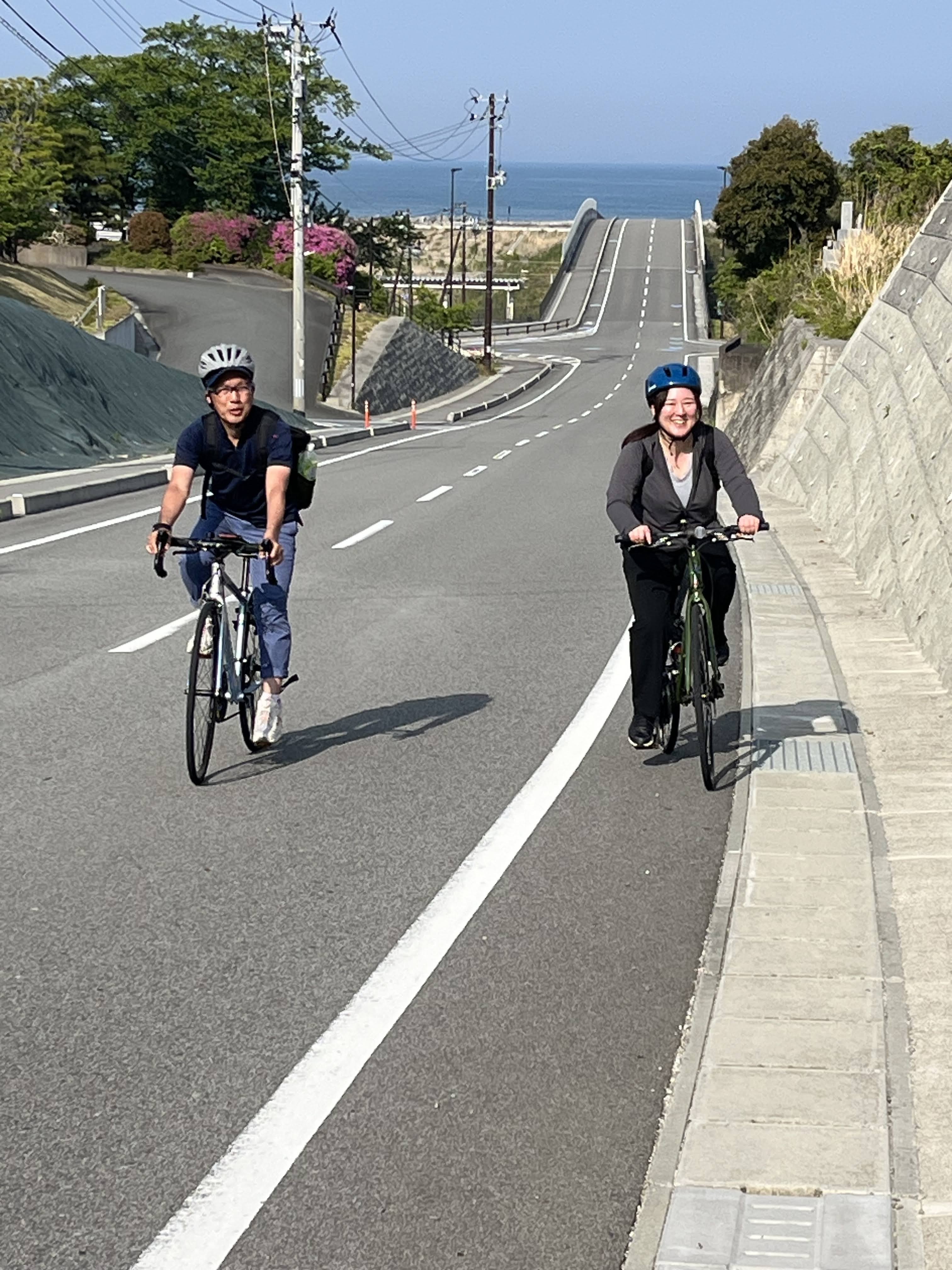 海が見える坂道を走るふくしま浜通りサイクルツアーの参加者