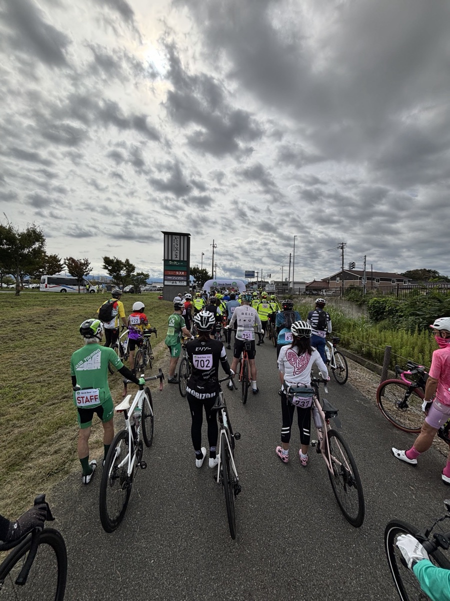自転車を押してスタートゲートへ向かう参加者の列