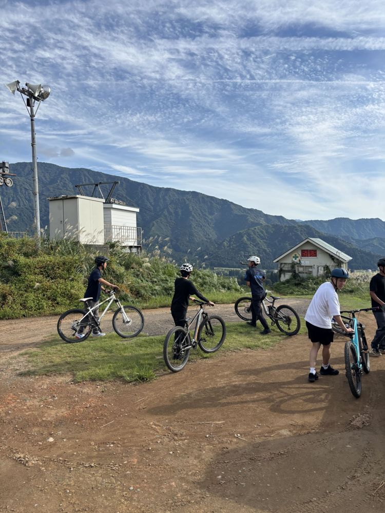 八海山麓マウンテンバイクパークでマウンテンバイクを押してコースへ向かう参加者